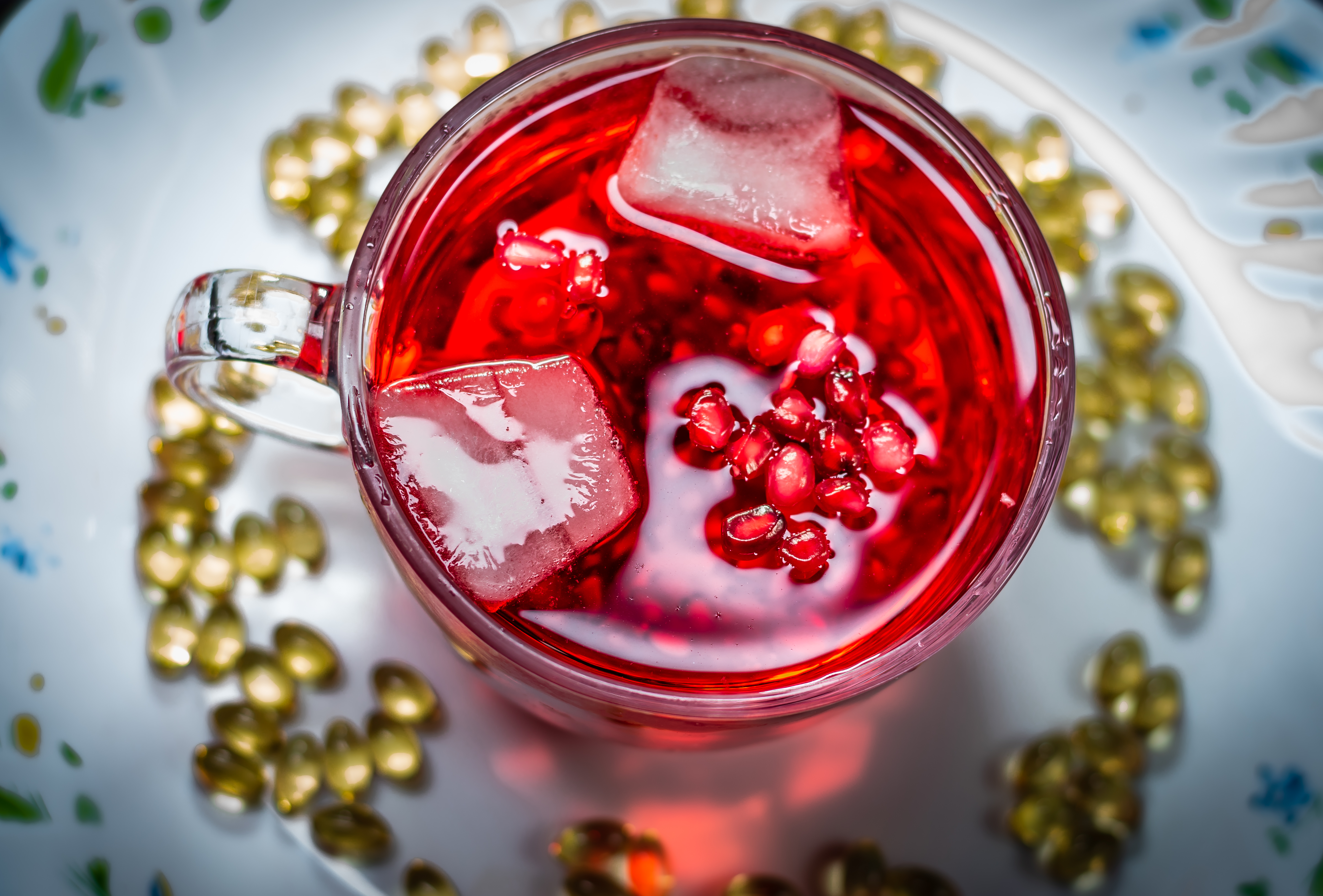 Sok z granatu z kostkami lodu w szklanej szklance